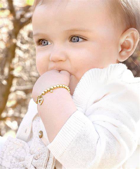 Baby girl wearing gold baptism bracelet